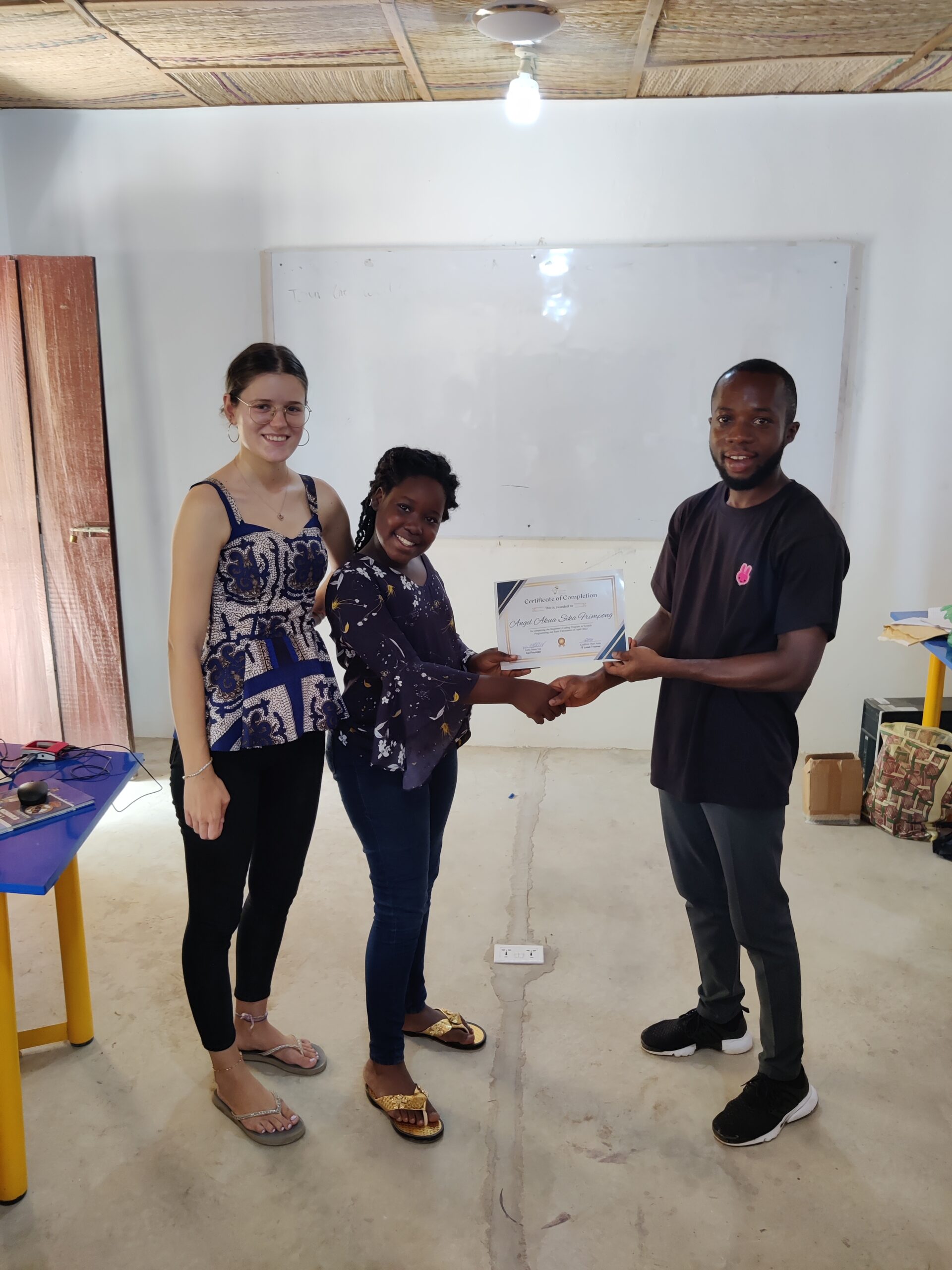 Trainers and student present her certificate